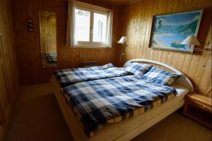 a bedroom with a bed with a plaid blanket and a window at Oreas (724 Du) in Valbella