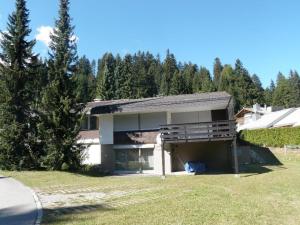 a house with a garage with trees in the background at Gentiana (463 Li) 4-ZW in Valbella