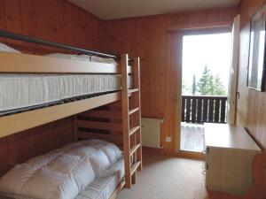 1 Schlafzimmer mit Etagenbetten, einem Schreibtisch und einem Fenster in der Unterkunft Montalin (452 Ti) 2. Stock in Valbella