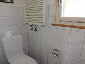ein weißes Bad mit einem WC und einem Fenster in der Unterkunft Montalin (452 Ti) 2. Stock in Valbella