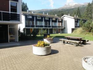 a picnic table and a bench in front of a building at Las Bargias 12 (407 Ho) in Lenzerheide
