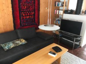 uma sala de estar com um sofá preto e uma mesa em Las Bargias 12 (407 Ho) em Lenzerheide