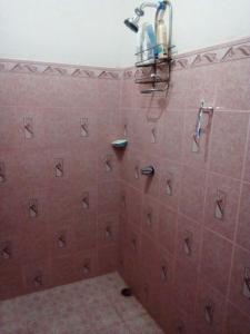 y baño con ducha y azulejos de color rosa. en Homestay Matagalpa en Matagalpa