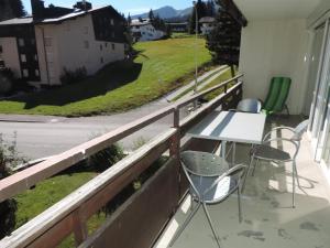 d'un balcon avec des chaises et une table offrant une vue sur la rue. dans l'établissement Ladina 65 (319 St), à Lenzerheide
