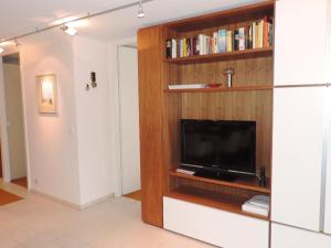 uma sala de estar com televisão e uma estante de livros em Ladina 74 (363 Ko) em Lenzerheide