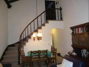 a living room with a staircase with a table and chairs at La Schmetta 5 (334 Fo) in Lenzerheide