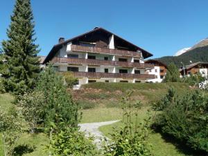un grande edificio in cima a una collina con alberi di Bella Val (206 Se) a Lenzerheide