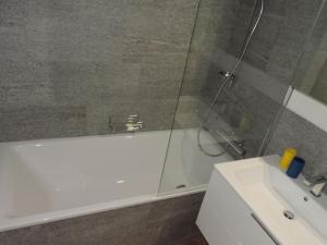 een badkamer met een douche, een bad en een wastafel bij Bella Val (272 Pe) in Lenzerheide