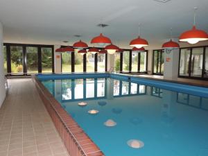 a large swimming pool with blue water in a building at Astoria (104 Mu) in Lenzerheide