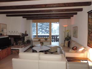 a living room with a white couch and a table at Sil Bot (3000 Bw) in Lenzerheide