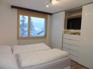 Una habitación blanca con una cama y una ventana en Sil Bot (3000 Bw), en Lenzerheide