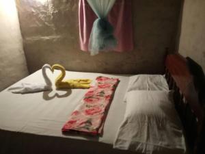a bed with two pillows and a towel on it at La Ceibita Tours in Los Potrerillos +13 photos