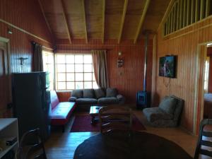 een woonkamer met een bank en een tafel bij Cabañas Quetalmahue in Ancud +44 foto's