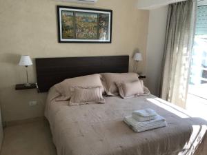 een slaapkamer met een groot bed met twee handdoeken erop bij Don Ramon Departamentos Premium in Tandil +15 foto's