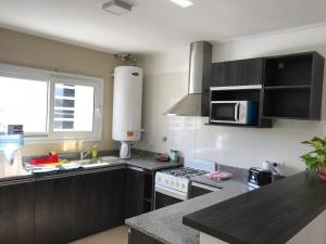 een keuken met een spoelbak en een fornuis bovenste oven bij Don Ramon Departamentos Premium in Tandil