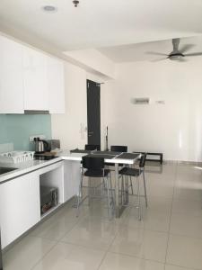 a kitchen with white cabinets and a table and chairs at CBD3 SOHO in Cyberjaya