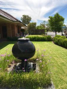 a large vase sitting in the grass in a yard at Cascades Motor Inn in Dubbo