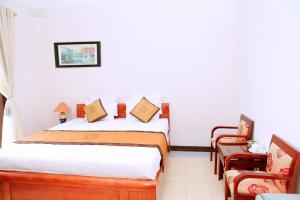 a bedroom with a bed and two chairs at Khách Sạn Cây Thông in Tam Ðảo +16 photos