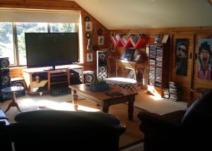 Una sala de estar con un televisor grande y una mesa. en High On Penguin, en Penguin