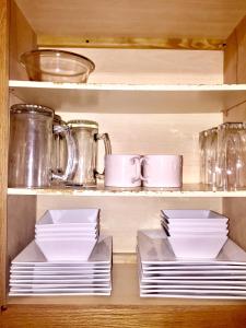 a cabinet filled with plates and cups and dishes at Premier National Harbor House in Fort Washington
