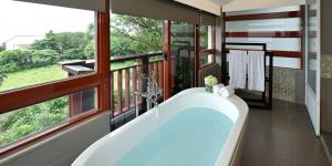 a bath tub sitting next to a window in a house at Fullon Hotel Fulong in Gongliao