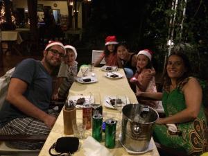 a group of people sitting at a table wearing santa hats at Ninila Fruit Farm Bungalow in Phú Quốc