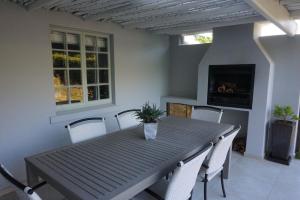 a dining room table with chairs and a fireplace at 5 Pierre Jourdan in Franschhoek