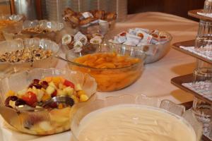 una mesa cubierta con tazones de fruta y otros alimentos en Jugendgästehaus St. Gilgen en Sankt Gilgen