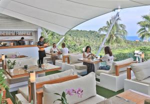 a restaurant with a view of the ocean at Code Samui Hotel in Mae Nam