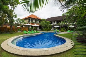 a swimming pool in the yard of a house at Bali Wirasana Inn in Sanur