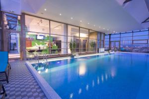 duży basen w dużym budynku w obiekcie Ramada by Wyndham Hotel Cluj w Klużu-Napoce