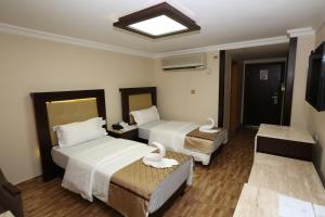 a hotel room with two beds with swans on them at Al Zaitouna Hotel in Aqaba