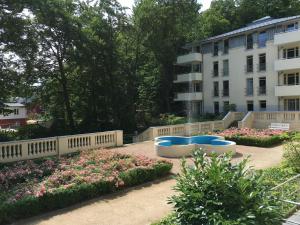 a garden in front of a building with flowers at Residenz Bleichröder - Ferienwohnung Aurelia in Heringsdorf