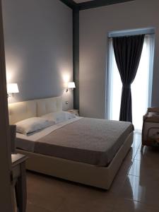 sypialnia z dużym łóżkiem i oknem w obiekcie Palazzo Bove w mieście Galatone