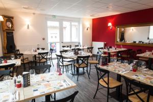 a restaurant with tables and chairs and red walls at Le Relais Délys in Saint-Rémy-sur-Durolle