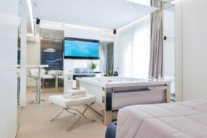 a white bathroom with a tub and a bedroom at P2 Kevin's Charming Houses in Alghero