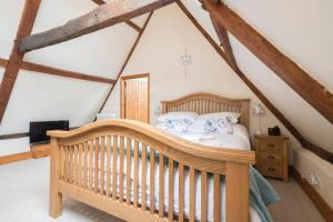 a bedroom with a crib in a attic at Church Farm Cottage Haysbro in Happisburgh