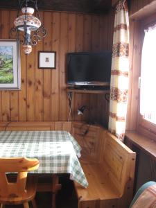 a dining room with a table and a tv at bruno piller hoffer in Sappada
