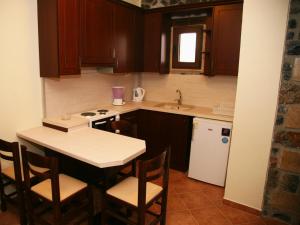 a small kitchen with a table and a sink at Yades Pozar in Kato Loutraki