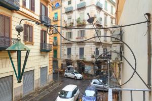 eine Stadtstraße mit Autos, die vor den Gebäuden geparkt sind in der Unterkunft Maison Du La Rua in Neapel