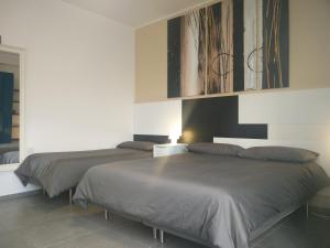 1 dormitorio con 2 camas y una pared con pinturas en B&B Via Roma 15, en Acquaviva delle Fonti