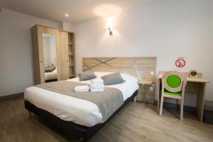 1 dormitorio con cama, escritorio y silla en Le Relais Délys, en Saint-Rémy-sur-Durolle