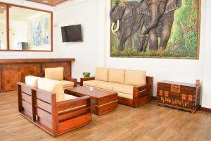 a waiting room with couches and a tv and a painting at Watergate Resort Unawatuna in Unawatuna