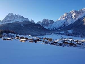 een resort met sneeuw bedekte bergen op de achtergrond bij Schattseiterhof in Sesto