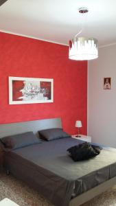 a bedroom with a red wall and a bed at La Casa sul Corso in Campora San Giovanni
