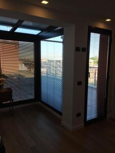 una sala de estar con grandes ventanas con persianas. en Suite Del Parco, en Monza