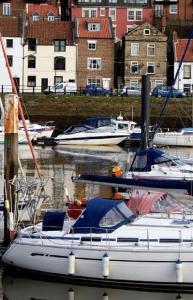 a white boat docked in a harbor with other boats at Laverick Steps in Whitby