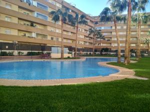 a swimming pool in front of a large building at Gran Plaza in Roquetas de Mar