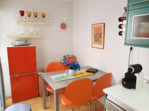 a kitchen with orange chairs and a table and a refrigerator at Gran Plaza in Roquetas de Mar