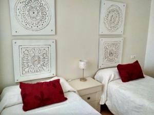 two beds in a room with two red pillows at Gran Plaza in Roquetas de Mar +12 photos